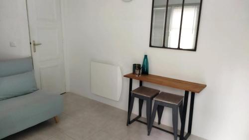 - une table et deux tabourets dans une pièce avec un miroir dans l'établissement Studio cosy à Paris 12m² avec terrasse privée, à Paris