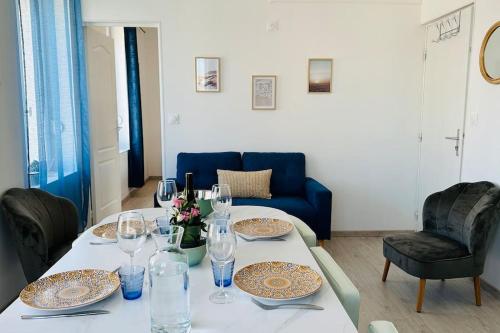 une table avec des assiettes et des verres à vin dessus dans l'établissement Chez Pierrot à 180m de la mer à Cayeux sur mer, à Cayeux-sur-Mer