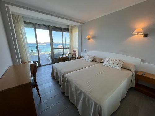 una camera d'albergo con due letti e vista sull'oceano di Hotel La Lanzada ad A Lanzada