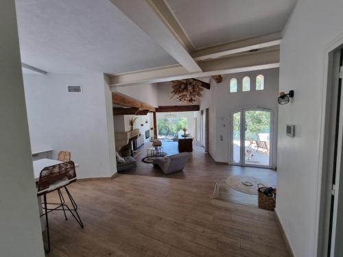 a living room with white walls and a wooden floor at Villa THAÏS in Nîmes