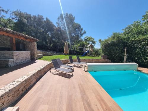a swimming pool with two lounge chairs and a swimming pool at Villa THAÏS in Nîmes