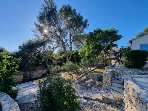 a garden with stone steps and a tree at Villa THAÏS in Nîmes