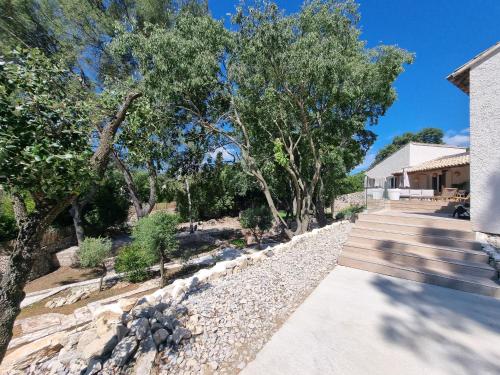 a walkway next to a house with trees at Villa THAÏS in Nîmes