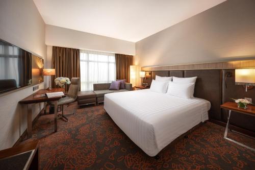 a hotel room with a bed and a television at Pullman Hanoi in Hanoi