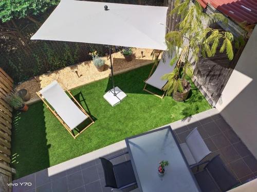 an overhead view of a backyard with a table and chairs at Jolie maison paisible, avec jardinet et parking in Gujan-Mestras