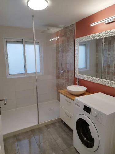 une salle de bain avec une machine à laver et un lavabo dans l'établissement Longère à Saint Michel chef chef, à Saint-Michel-Chef-Chef