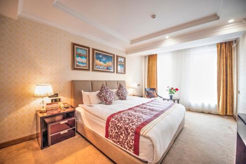a hotel room with a large bed and a television at Royal House Hotel 2 in Ulaanbaatar