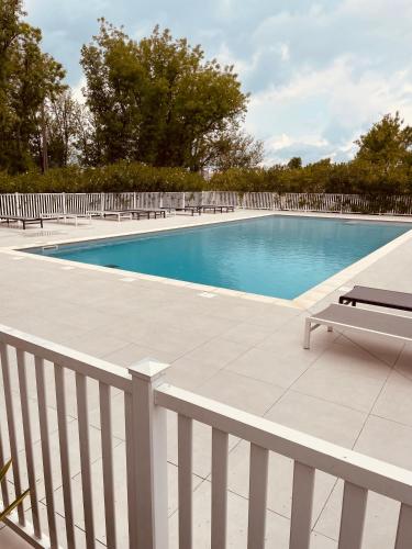 - une piscine avec un banc à côté d'une clôture dans l'établissement Domaine des bastidons, à Mas blanc des Alpilles