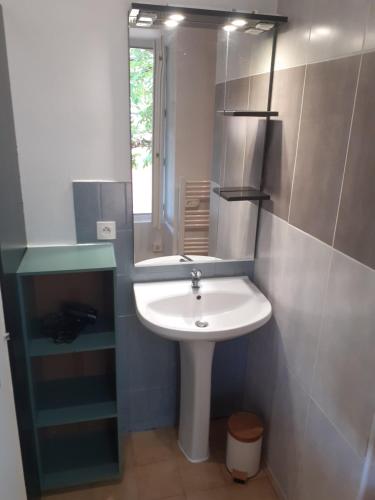 une salle de bain avec un lavabo blanc et un miroir dans l'établissement Gîte à deux pas de Sarlat Calme et paisible, à Proissans