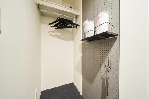 a walk in closet with white walls at Rakuten STAY Osaka Station North in Osaka