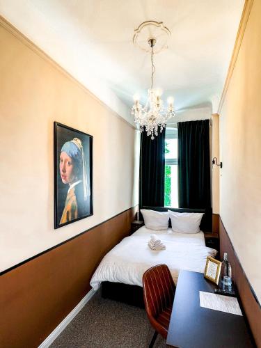 a bedroom with a bed and a painting on the wall at Pension Am Park in Berlin