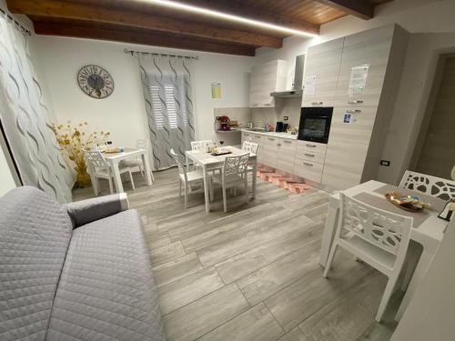 een woonkamer met een tafel en stoelen en een keuken bij B&B al Vicoletto in Bellante