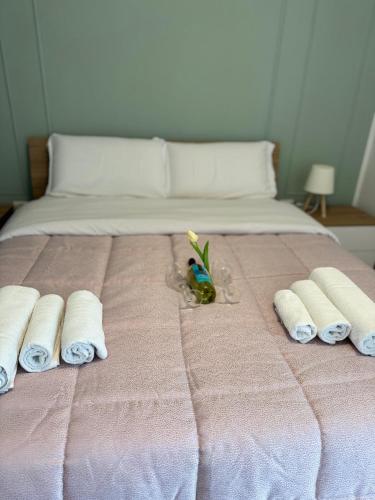 a pink bed with towels and a toy on it at Green House Next - Lovely Apartment for family and Free Parking in Levico Terme