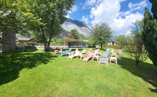 a row of chairs sitting on the grass with a mountain at La Marmotte De La Meije in Le Bourg-dʼOisans