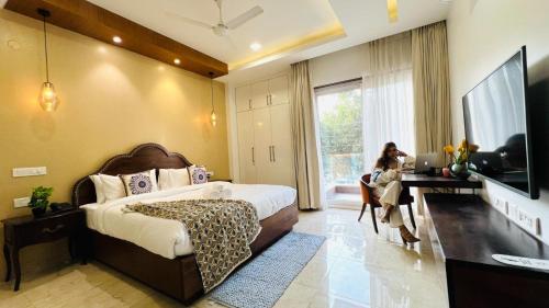 a bedroom with a bed and a desk and a television at BluO Luxury Stay - Medicity - Balcony, Tub, Gym TT in Gurgaon