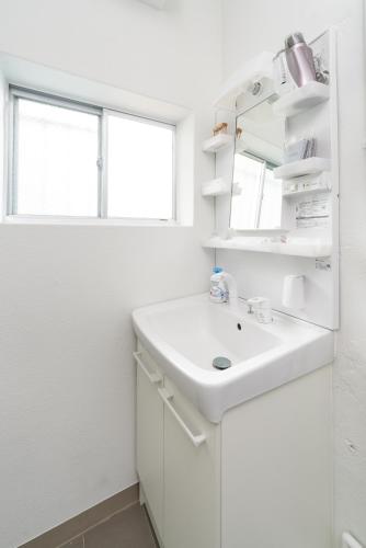 a white bathroom with a sink and a window at GranGiorno HAKONE Kowakidani in Ashinoyu