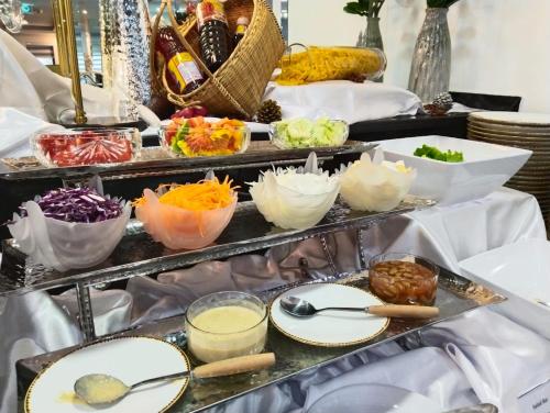 a buffet of food with plates and bowls of food at SureStay Hotel by Best Western Vientiane in Vientiane