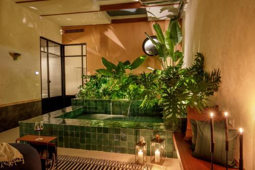a bathroom with a tub with plants and candles at Officina Daplace in Rome