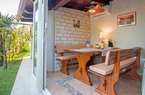 a patio with a wooden table and a bench at Studio Apartment Oliva in Pula