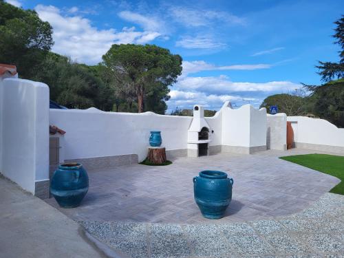 three blue vases sitting on a patio next to a white wall at Casa Vacanza Boi-Dessena in Cala Liberotto