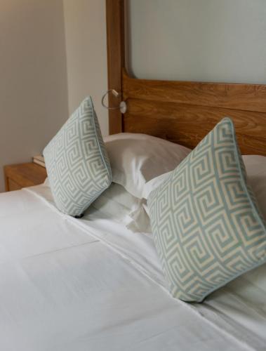 a bed with two pillows on top of it at The Cove in Panwa Beach