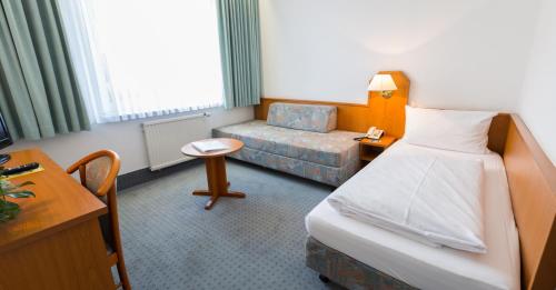 um quarto de hotel com uma cama e uma cadeira em Zum Starenkasten GmbH em Braunschweig