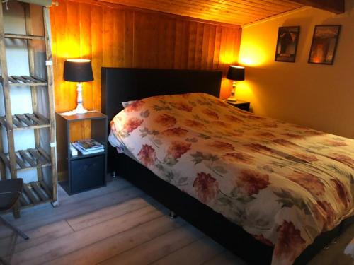 une chambre avec un lit avec une couette fleurie dans l'établissement Domaine Lapin Qui Rit , chambre Céline, à Saint-Jean-de-Côle