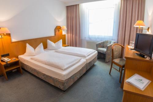 um quarto de hotel com uma cama e uma televisão em Zum Starenkasten GmbH em Braunschweig