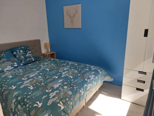 - une chambre bleue avec un lit et un mur bleu dans l'établissement Charmant Plain pied, 200m du port, Appart 2, à Binic