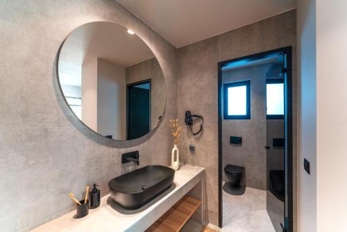 a bathroom with a black sink and a mirror at Afesou Suites in Ialyssos
