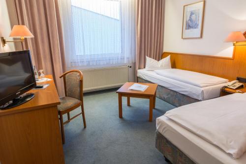 um quarto de hotel com duas camas e uma televisão em Zum Starenkasten GmbH em Braunschweig