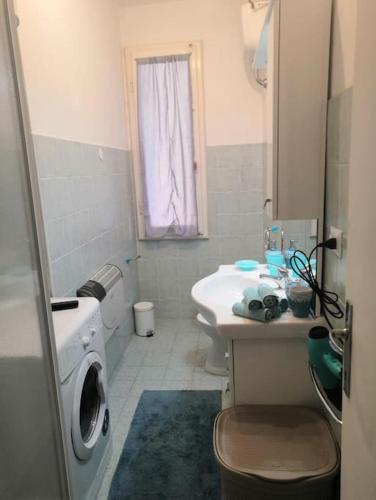 a bathroom with a sink and a washing machine at Lo Scorcio sul porto in Porto Santo Stefano