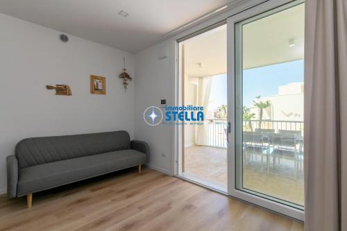 a living room with a couch and a sliding glass door at Wave Island in Lido di Jesolo
