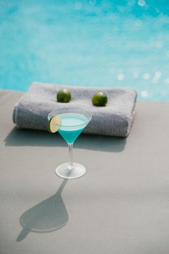 a drink in a glass next to a pool at Mr and Mrs White Paros in Naousa