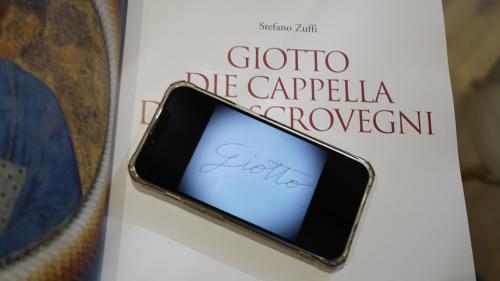 a book with a cell phone on a table at Diana's luxury guest house in Padova