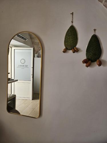 a mirror on a wall next to a bathroom with a mirror at Muribel Maison in Ceglie Messapica
