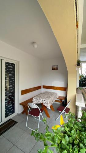 a patio with a table and chairs in a room at Apartment Tanya in Petrovac na Moru
