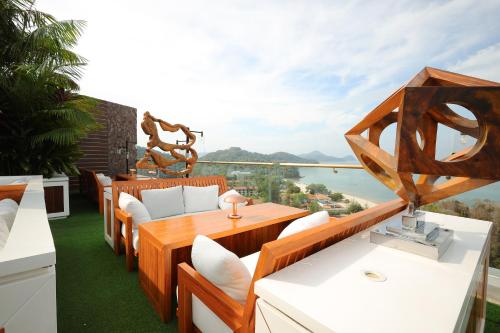 balcón con muebles de madera y vistas al agua en The RIYAZ Lavanya en Pantai Cenang