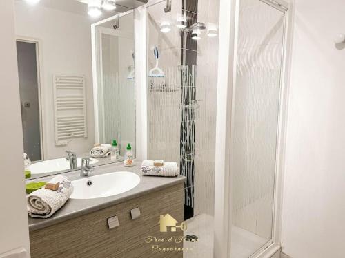 a bathroom with a sink and a shower at Au gré des Vagues, vue mer, wifi, piscine chauffée in Concarneau