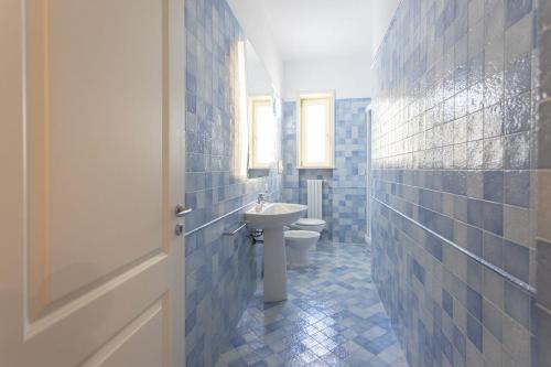 ein blau gefliestes Bad mit WC und Waschbecken in der Unterkunft Trilocale Corso Italia 25 piano terra con spazio esterno in Gallipoli