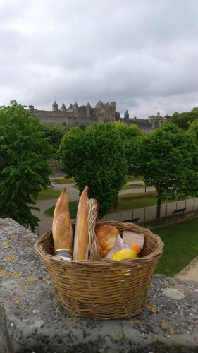 ein mit Brot gefüllter Korb auf einer Mauer in der Unterkunft L'Onde des berges de l'Aude in Carcassonne