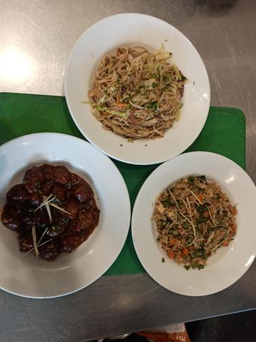 tres platos de comida sobre una mesa en Solis Wellness Retreat, en Hoshiārpur