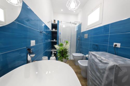 a blue and white bathroom with a toilet and a tub at Terra Sinus Beautiful Suite in Terrasini