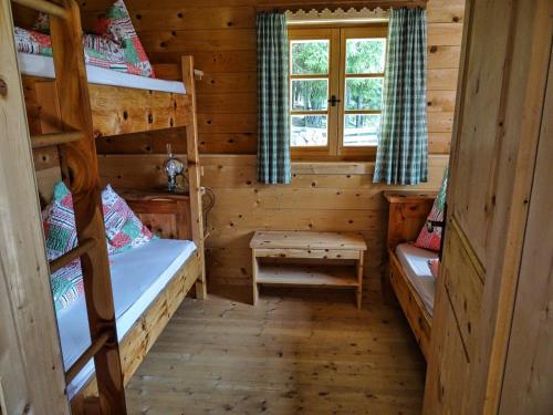 a room with two bunk beds in a log cabin at Bergquellenhütte in Assling