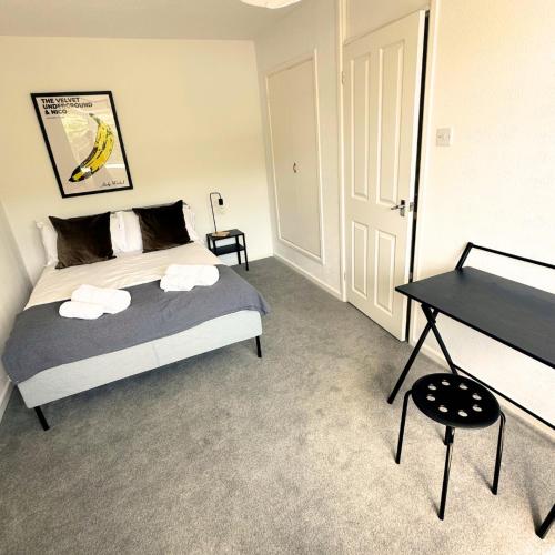 a bedroom with a bed and a desk in it at Newly refurbished 2 bed in Thame in Thame