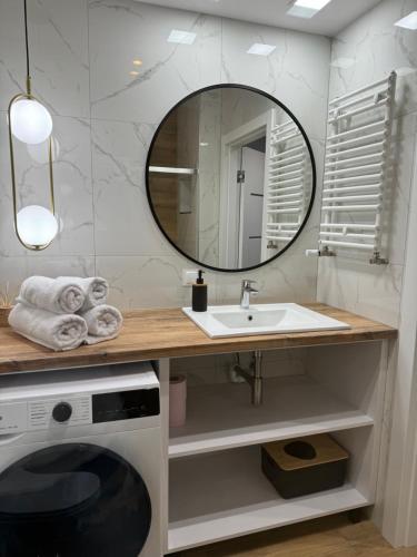 un baño con lavabo y espejo en Apartamenty Baltic Sea Kasprowicza 20, en Kołobrzeg