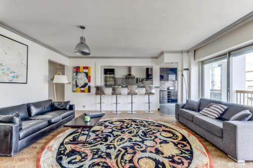 un salon avec des canapés et un tapis dans l'établissement Appartement avec balcon Quartier branché, à Paris