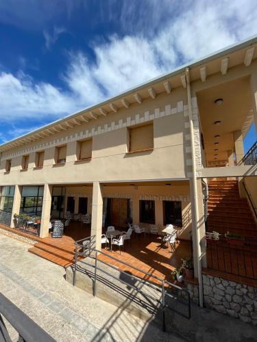 ein Gebäude mit Treppen und Tischen und Stühlen in der Unterkunft Hostal La Rurala Estopanyà in Estopiñán