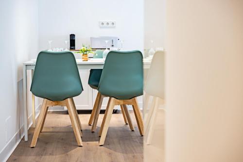 een keuken met twee groene stoelen aan een aanrecht bij Hostal Paris in Valladolid