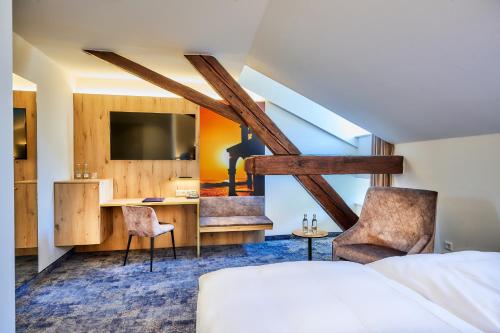 um quarto de hotel com uma cama, uma secretária e cadeiras em Hotel Zur Post Altötting em Altötting